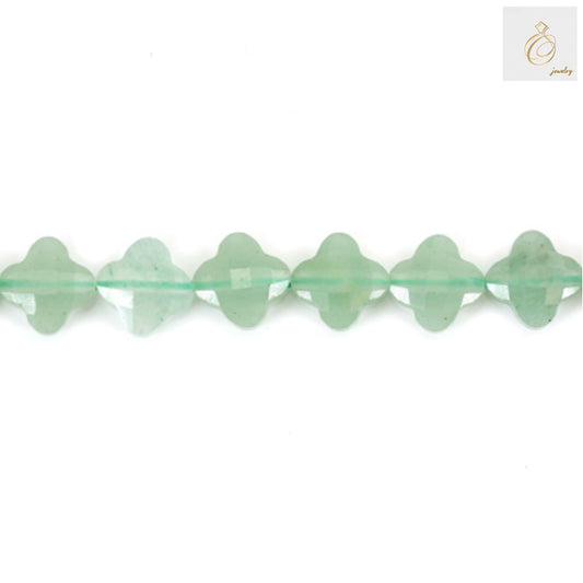 Close-up view of green aventurine clover-shaped beads displaying faceted surface and natural stone patterns