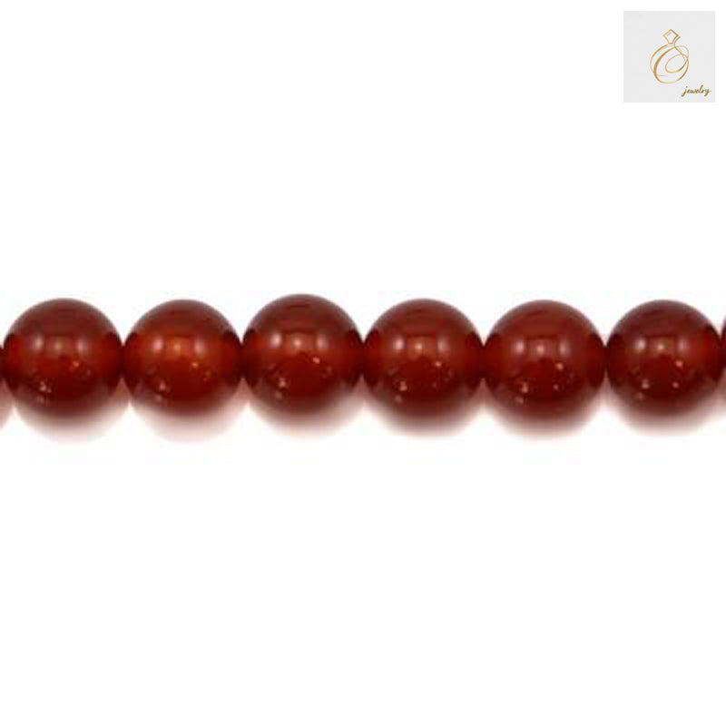 Close-up view of 10mm red agate gemstone beads displaying natural banding patterns and deep red tones