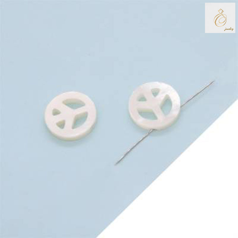 Close-up view of white mother-of-pearl peace and love heart charm showing detailed craftsmanship and natural shell texture