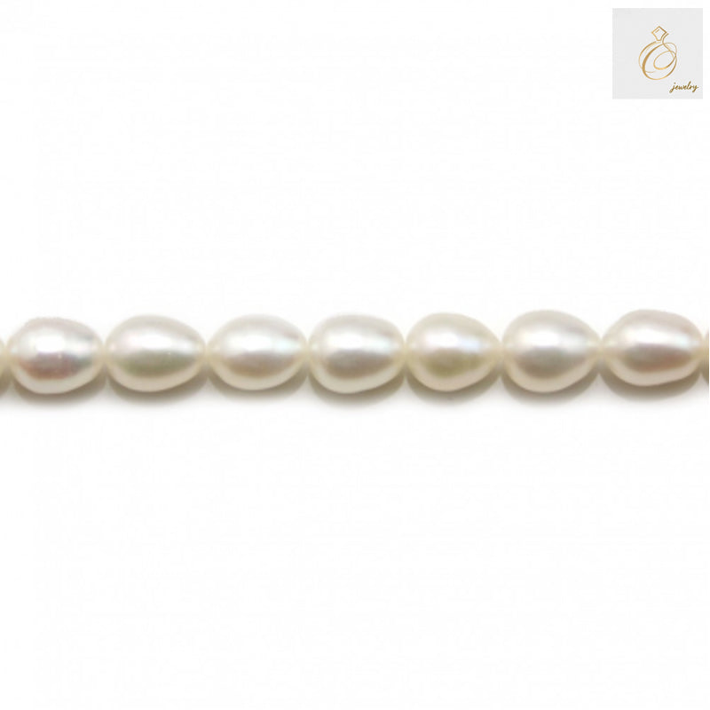 White freshwater cultured pearl strand with oval 6-7mm pearls, 39-40cm length"
"Premium white oval freshwater pearls arranged in strand for jewelry making"
"Close-up of lustrous white cultured pearls showing natural nacre and smooth surface