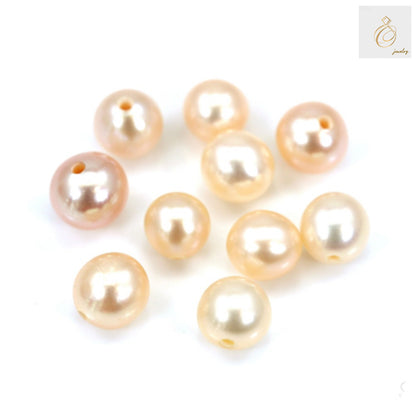 Close-up view of champagne freshwater cultured pearl beads showing lustrous surface and round shape, half-drilled for jewelry crafting
