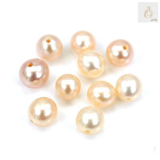 Close-up view of champagne freshwater cultured pearl beads showing lustrous surface and round shape, half-drilled for jewelry crafting
