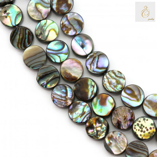 Close-up view of 12mm abalone paua shell round beads showing natural iridescent patterns and 1mm holes for jewelry crafting