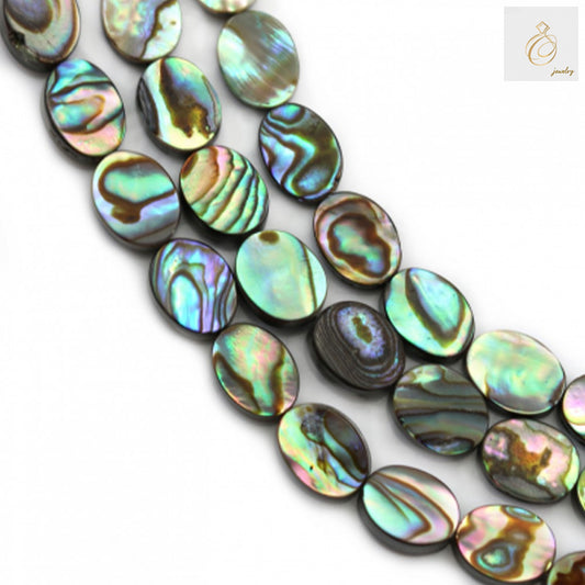 Close-up view of abalone paua shell oval beads displaying natural rainbow iridescence and smooth finish
