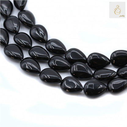 Black Agate Teardrop Gemstone Strands - Multiple strands of 9x13mm black agate teardrop beads arranged on white background