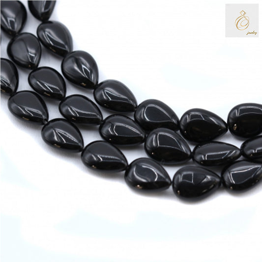 Black Agate Teardrop Gemstone Strands - Multiple strands of 9x13mm black agate teardrop beads arranged on white background