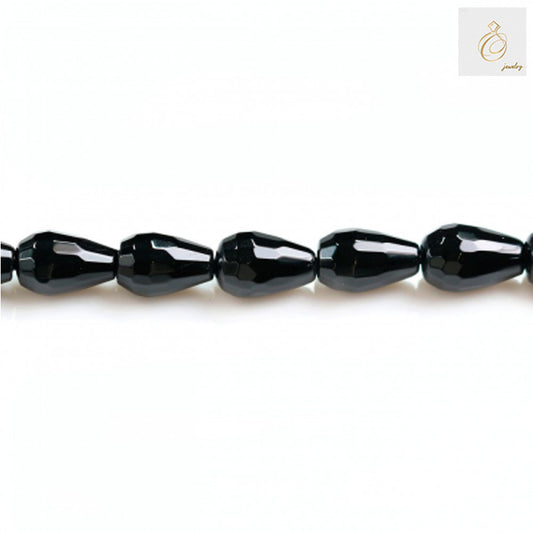 Close-up view of black agate faceted teardrop beads in a single strand highlighting the precise faceting and glossy surface