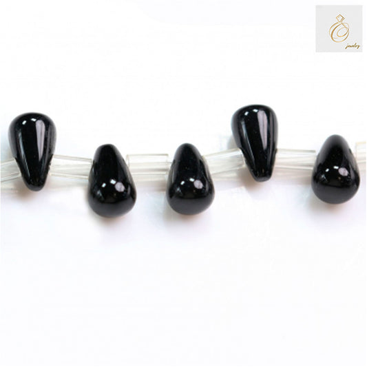 Close-up of five black agate teardrop beads 5x8mm showing glossy finish and uniform shape