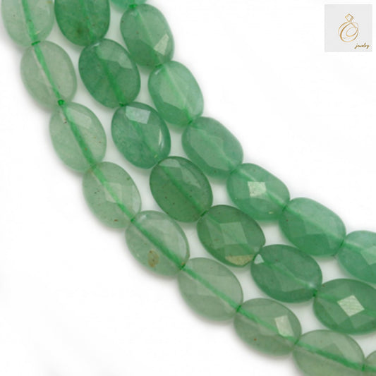 Green aventurine faceted oval beads 6x8mm arranged on strand showing natural gemstone color and cut quality