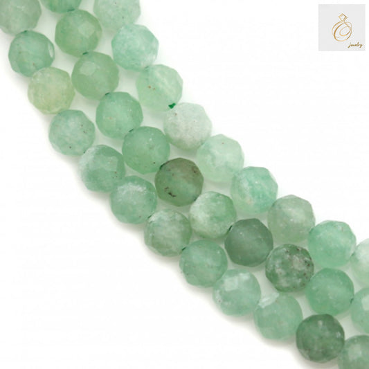 Green aventurine faceted round beads 4mm size arranged on white background showing natural green color and sparkly faceted surface