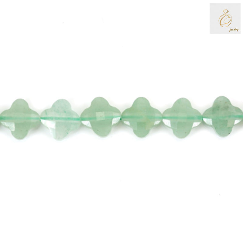 Close-up view of green aventurine clover-shaped beads displaying faceted surface and natural stone patterns