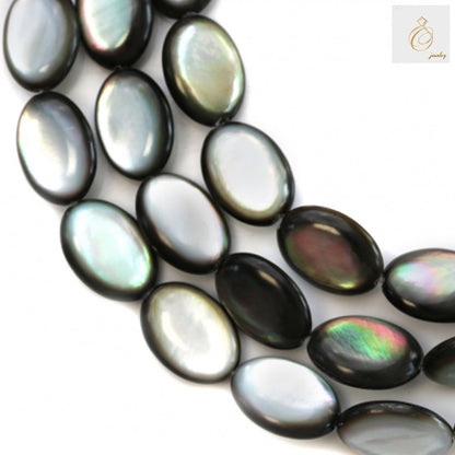 Close-up view of grey mother of pearl shell beads displaying the flat oval shape and natural iridescent texture