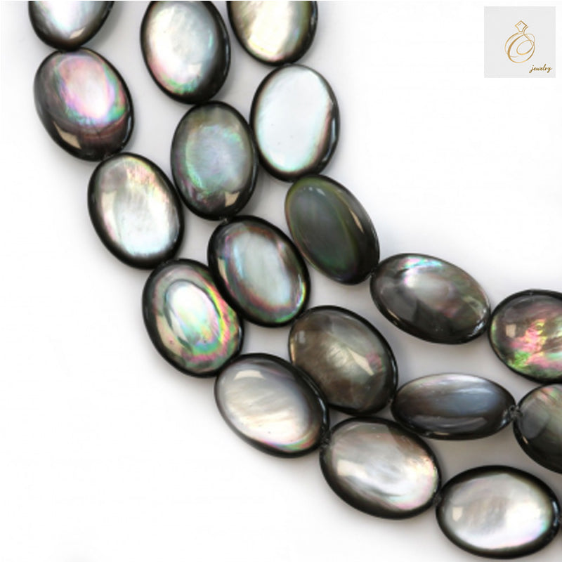 Close-up view of grey mother of pearl shell beads showing flat oval shape and natural luster
