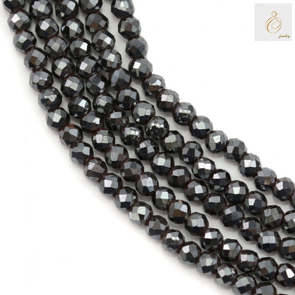 Close-up view of hematite faceted round beads 2mm showing detailed faceted surface and hole
