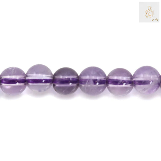 Close-up view of 4mm light amethyst round beads showing consistent size and natural purple coloring, ideal for jewelry making