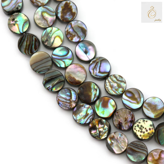 Close-up view of natural abalone shell beads displaying the lustrous surface texture and 6mm flat round shape