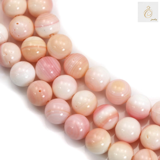 Close-up view of natural pink mother of pearl shell beads displaying iridescent surface and uniform 10mm diameter
