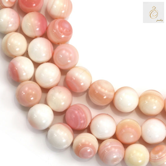 Close-up view of natural pink mother of pearl shell beads showing texture and color variations