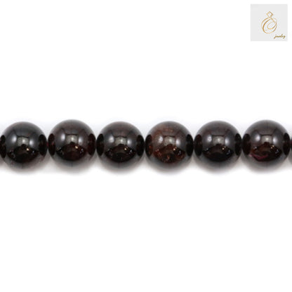 Close-up view of natural garnet beads showing deep red color and smooth round shape