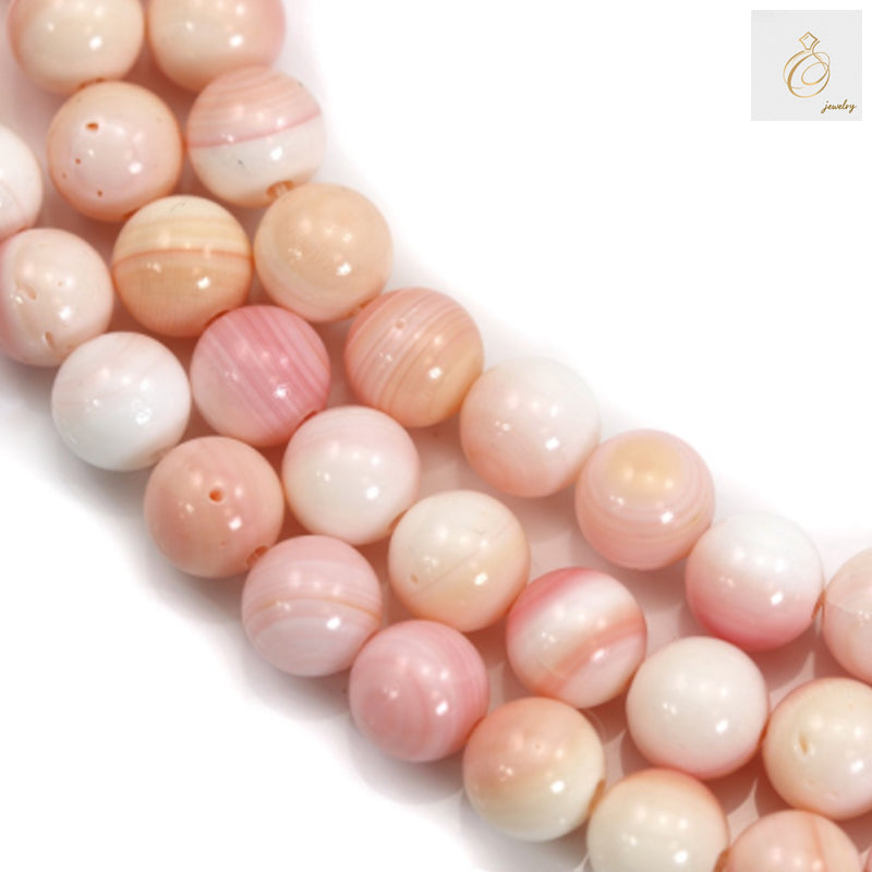 Close-up view of natural pink mother of pearl shell beads showing texture and color variations, 8mm diameter
