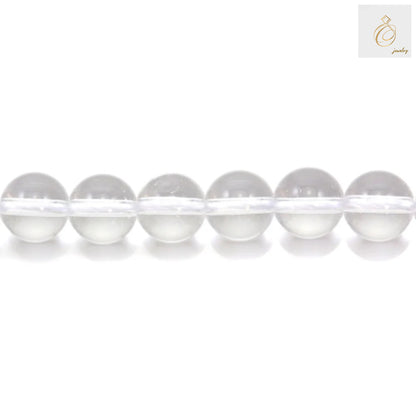 Close-up view of natural rock crystal beads showing clarity and round shape, 6mm diameter jewelry making supplies