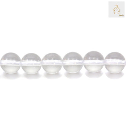 Close-up view of natural rock crystal beads showing clarity and round shape, 8mm diameter gemstone beads for jewelry making