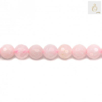 Close-up view of natural rose quartz beads showing faceted surface and pink color