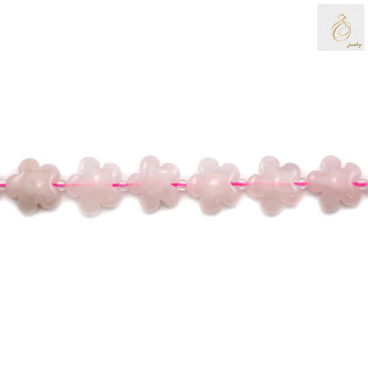 Close-up view of natural rose quartz flower-shaped beads showing the delicate pink color and flower pattern detail