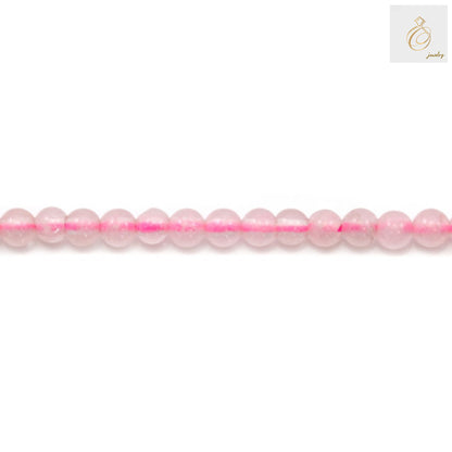 Close-up view of natural rose quartz beads showing pink color and round shape, 2mm diameter