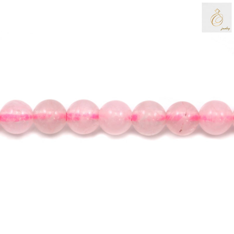Close-up view of natural rose quartz beads, 4mm round gemstones in soft pink color, perfect for DIY jewelry and craft projects