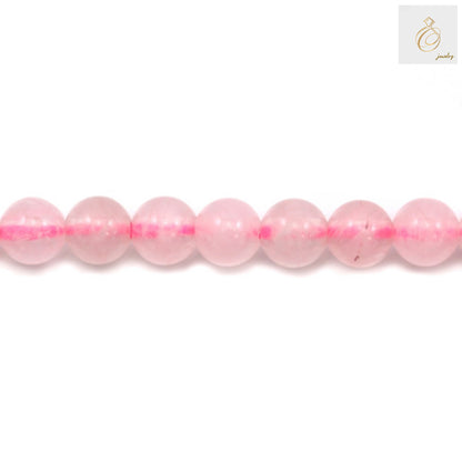 Close-up view of natural rose quartz beads, 4mm round gemstones in soft pink color, perfect for DIY jewelry and craft projects