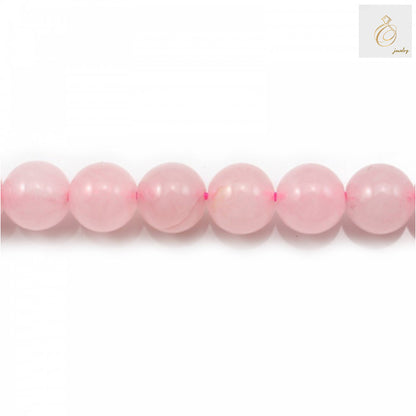 Close-up view of natural rose quartz beads showing pink color variations and smooth round shape, 6mm size