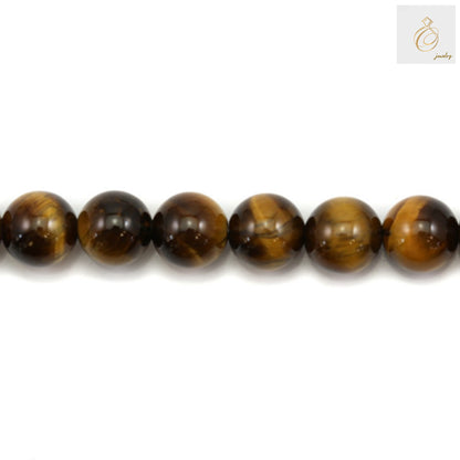 Close-up of natural yellow tiger's eye beads showing smooth polished surface and distinctive golden striped patterns