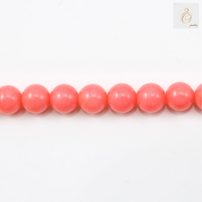 Pink sea bamboo round beads 6mm arranged on white background showing natural texture and color