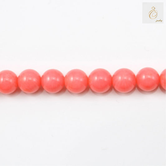 Pink sea bamboo round beads 6mm arranged on white background showing natural texture and color