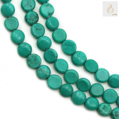 Reconstituted turquoise flat round beads 5mm diameter on strand - close-up view showing blue-green color and smooth finish