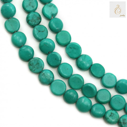 Reconstituted turquoise flat round beads 5mm diameter on strand - close-up view showing blue-green color and smooth finish