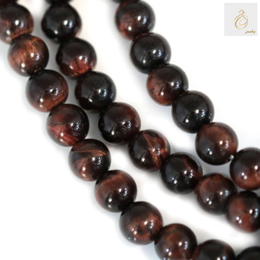 Red tiger's eye round beads strand 4mm diameter showing natural chatoyancy and reddish-brown color patterns