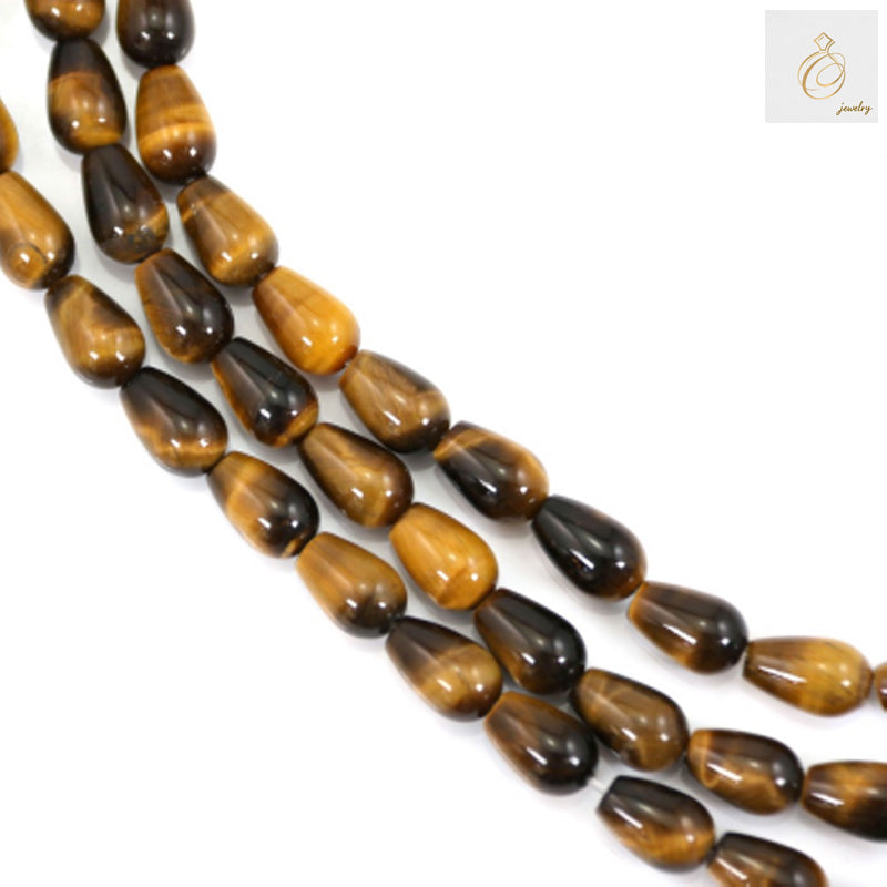 Natural tiger's eye drop beads 6x9mm arranged on strand showing golden-brown chatoyancy and smooth polished finish