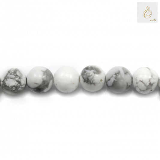Close-up view of white howlite beads showing smooth round shape and 1.2mm holes
