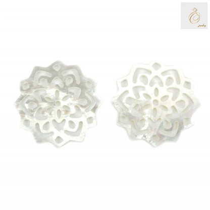 Close-up view of white mother-of-pearl shell floral charm showing natural iridescent finish and detailed craftsmanship