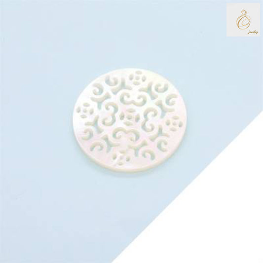 Close-up view of white mother-of-pearl shell charm showing detailed hollow pattern cutout and natural iridescent finish