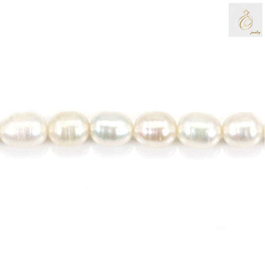 Close-up view of white freshwater cultured pearls showing lustrous surface and oval shape, 6-7mm size